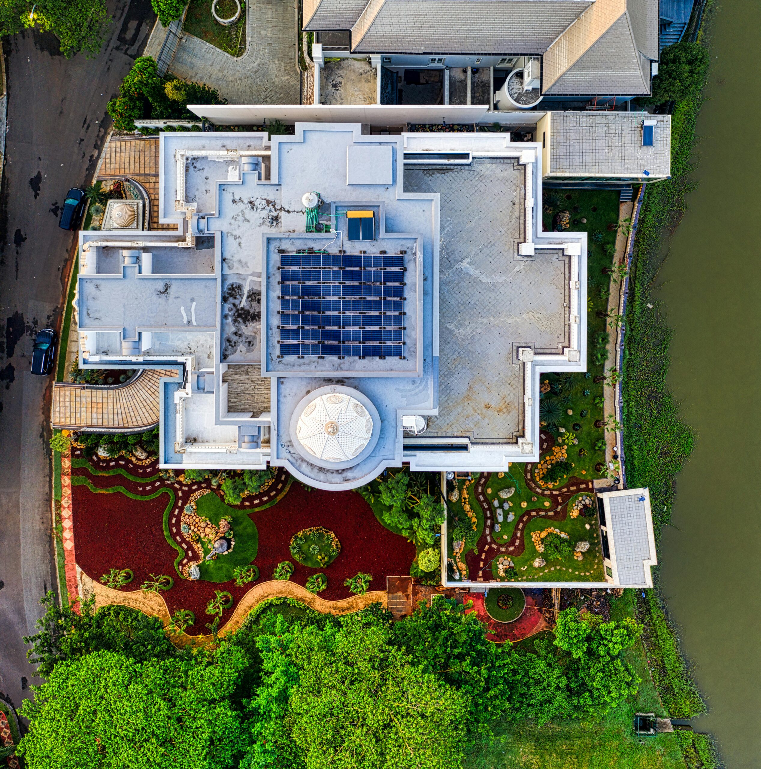 Top-down shot of a luxury tropical villa in Tangerang, Indonesia, featuring solar panels and lush gardens.
