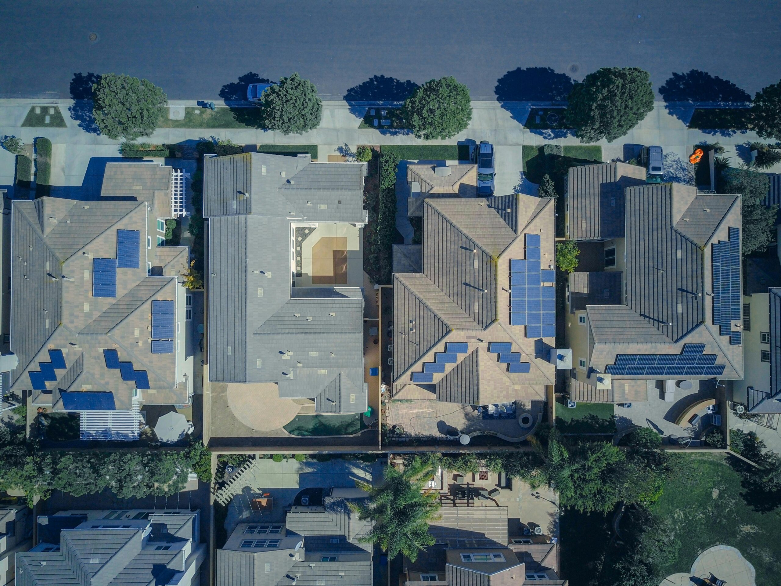 Top-down view of urban houses with solar panels emphasizing clean energy solutions.